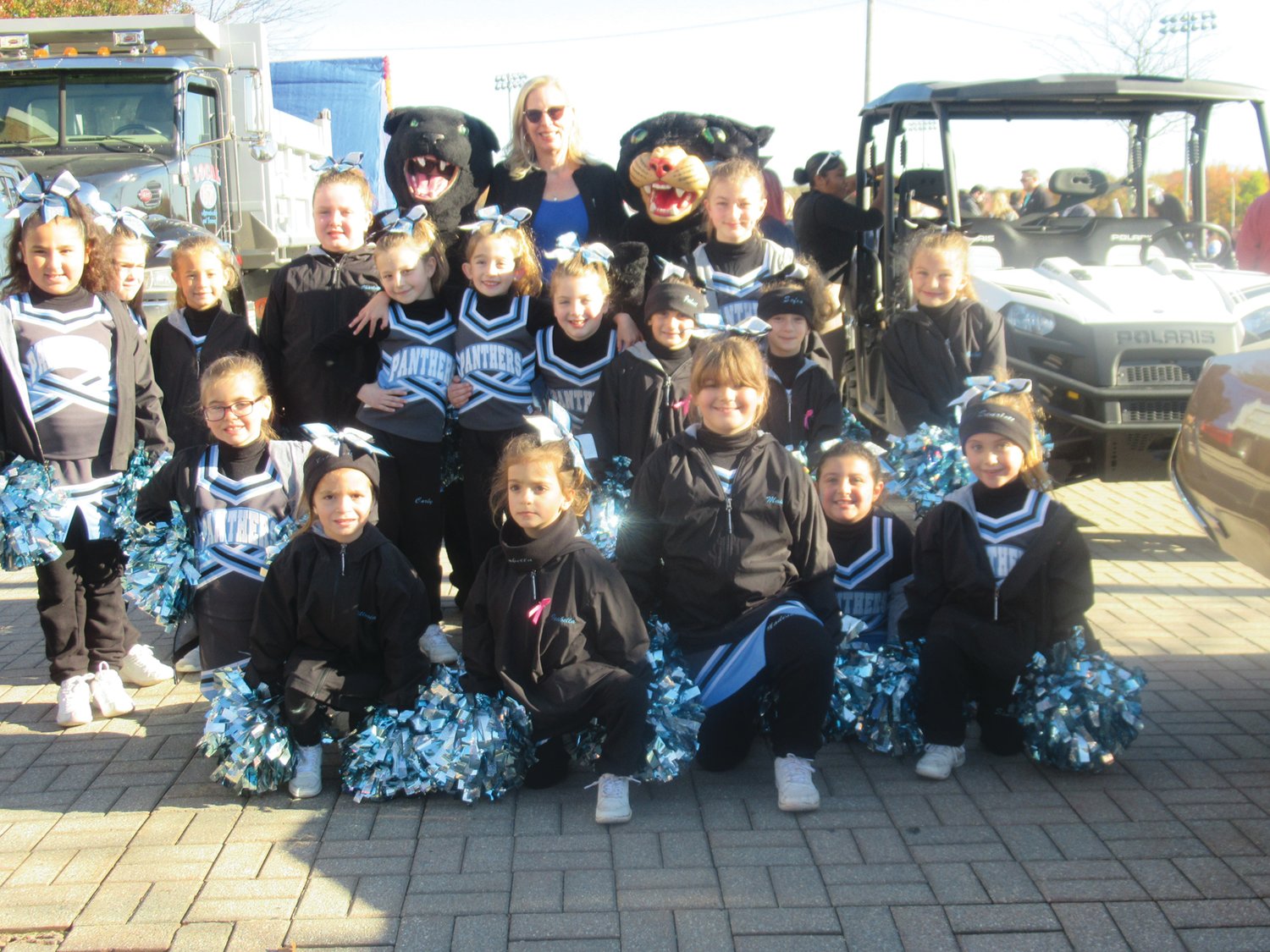 SUPER SPIRIT: Johnston School Committee member Dawn Aloisio is all smiles as she’s surrounding by cheerleaders from the town’s youth football program who marched in the Homecoming Parade along with two Panther mascots.